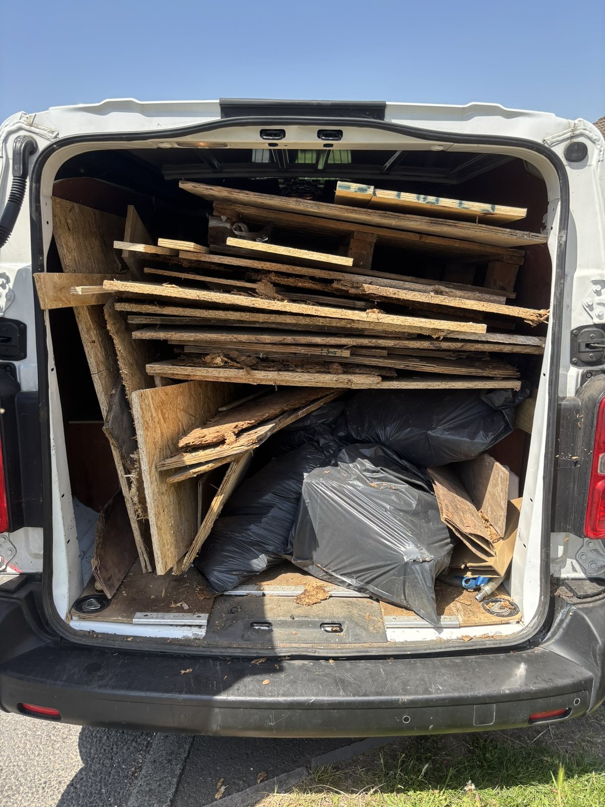 Timber and bagged waste loaded into a van for responsible waste transfer